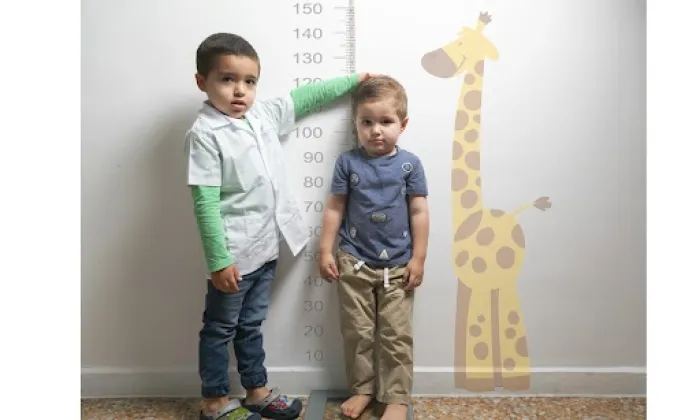 Niño midiendo a un niño más pequeño